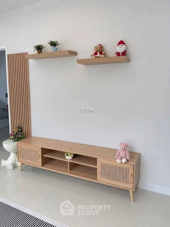 Modern living room with stylish wooden TV stand and decorative shelves.