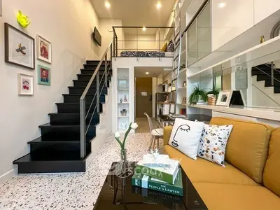 Stylish modern living room with mezzanine, cozy seating, and chic decor.