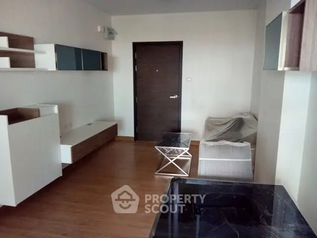 Modern living room with sleek furniture and wooden flooring in a stylish apartment.