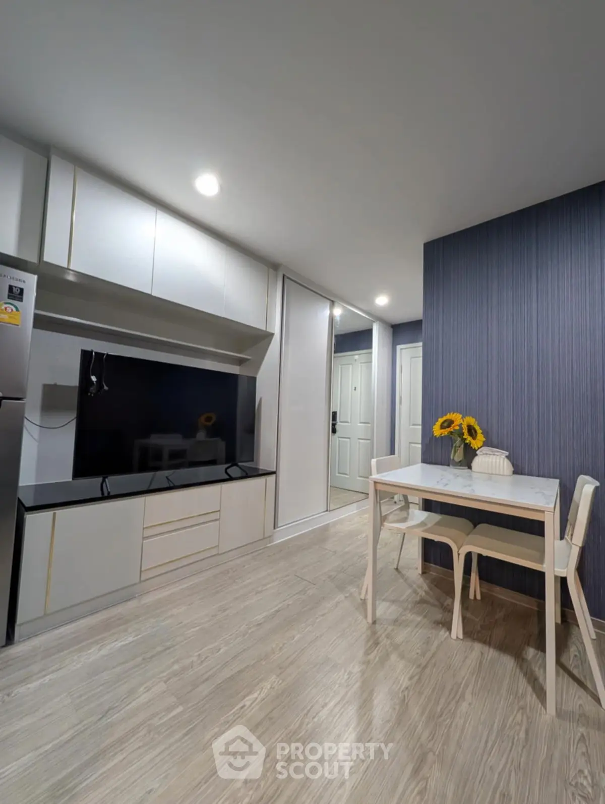 Modern kitchen with sleek cabinetry and dining area, featuring sunflowers for a touch of elegance.