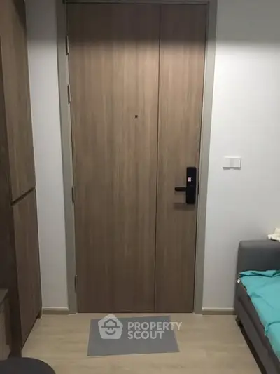 Modern apartment entrance with sleek wooden door and cozy interior design.