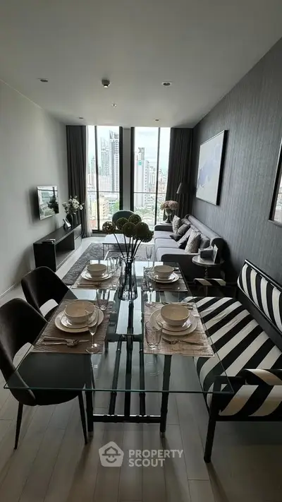 Modern living room with city view, stylish furniture, and elegant dining setup in a high-rise apartment.