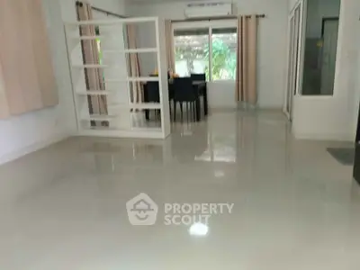 Spacious living room with glossy tiled floors and modern dining area.