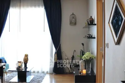 Elegant living room with large window, dark curtains, and stylish decor