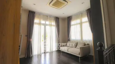 Bright living room with large windows and elegant curtains