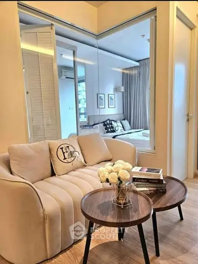 Modern living room with cozy sofa and view into stylish bedroom