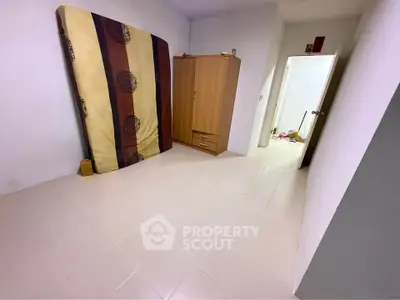 Spacious bedroom with wardrobe and mattress, ideal for customization.