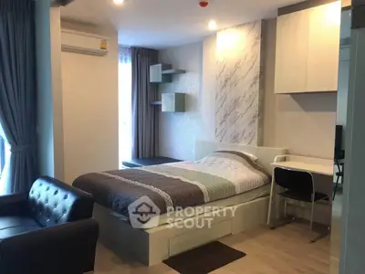Modern studio apartment with cozy bed, stylish sofa, and functional workspace.