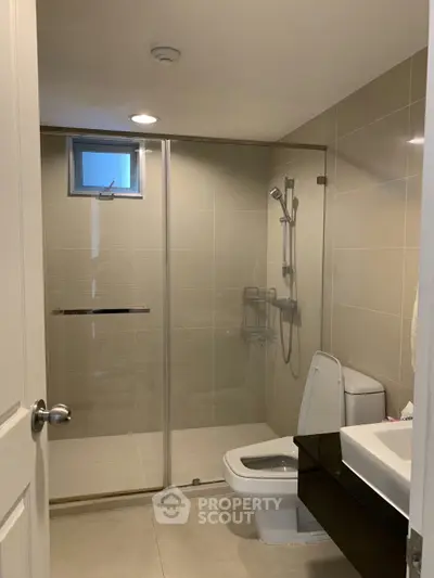 Modern bathroom with glass shower and sleek fixtures in a contemporary home.