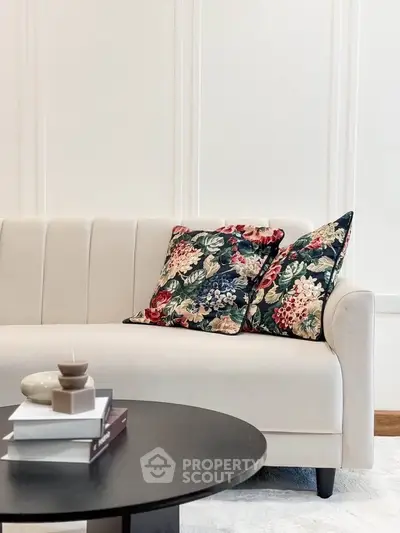 Elegant living room with floral cushions on a cream sofa and modern coffee table.