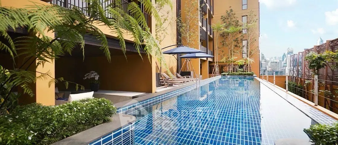 Luxurious rooftop pool with city skyline view in modern apartment complex.