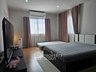 Spacious bedroom with modern decor and natural light, featuring a large bed and stylish curtains.