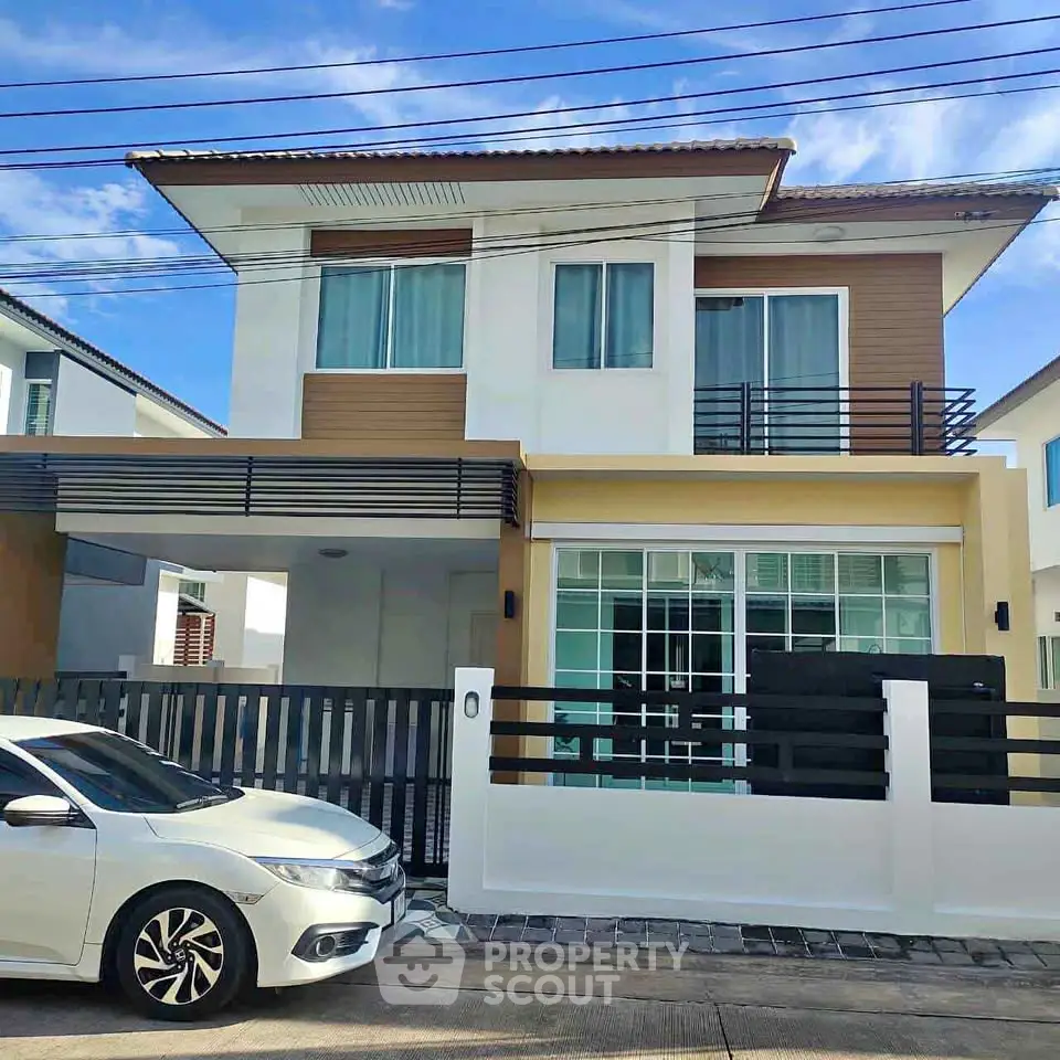 Modern two-story house with sleek design and large windows in a suburban neighborhood.