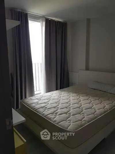 Cozy bedroom with large window and modern furnishings in a stylish apartment.