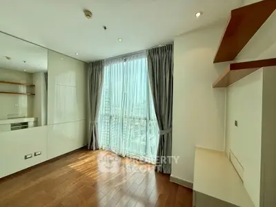 Bright and modern living room with floor-to-ceiling windows and wooden flooring in a high-rise apartment.
