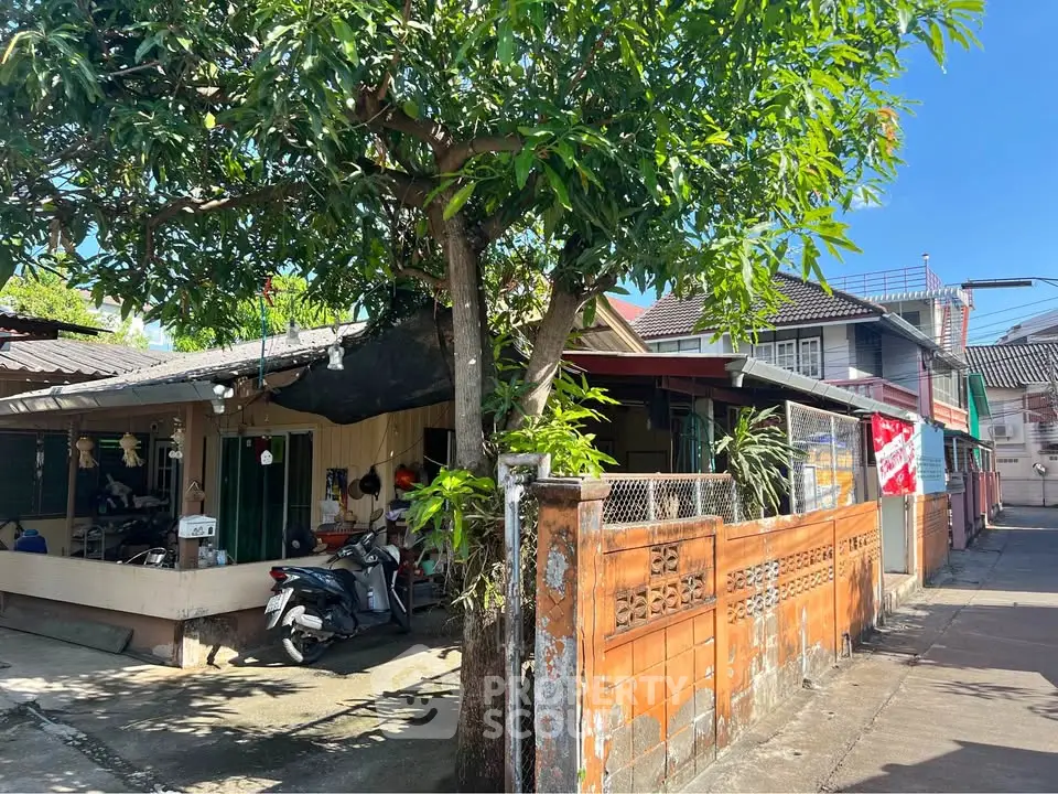 Charming suburban house with lush greenery and rustic fence, perfect for cozy living.