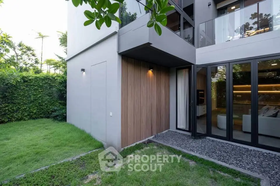 Modern townhouse exterior with lush garden and large windows for natural light.