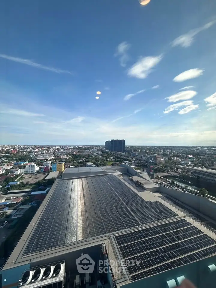 Stunning aerial view of urban landscape with solar panels and city skyline under clear blue sky.