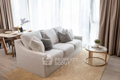 Elegant living room with plush sofa and stylish dining area, featuring floor-to-ceiling windows and chic decor.