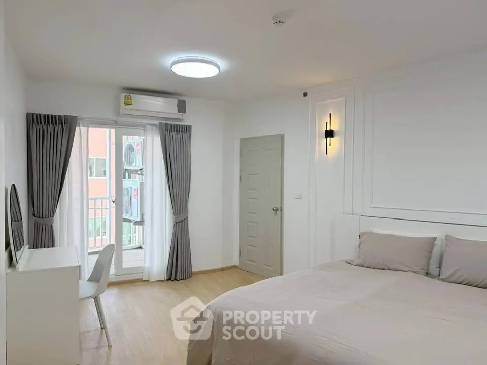 Modern bedroom with balcony access and stylish decor in a bright apartment.