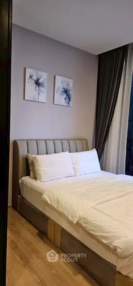 Modern bedroom with stylish decor and large window for natural light.