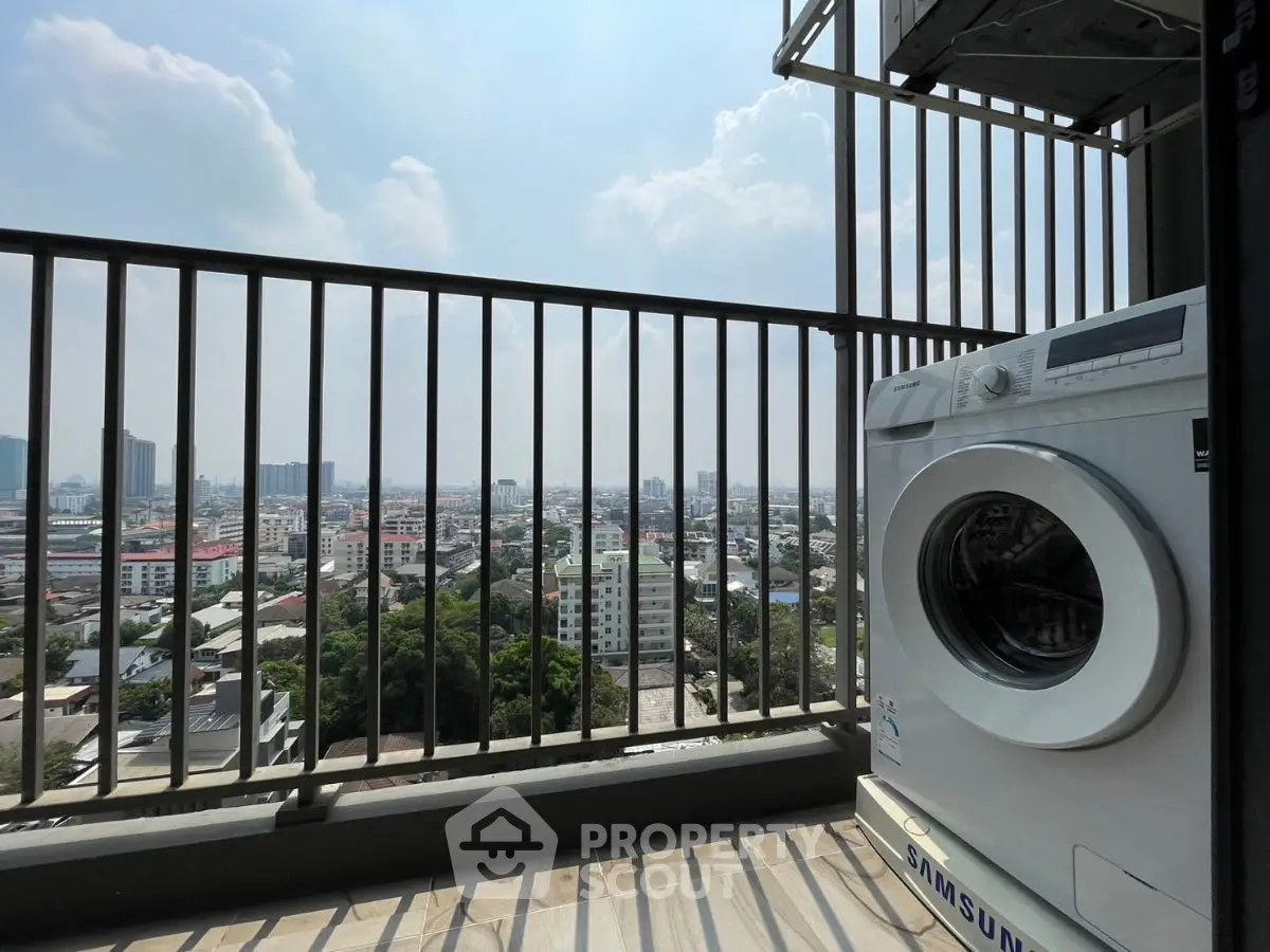 High-rise balcony with city view and washing machine, perfect for urban living.