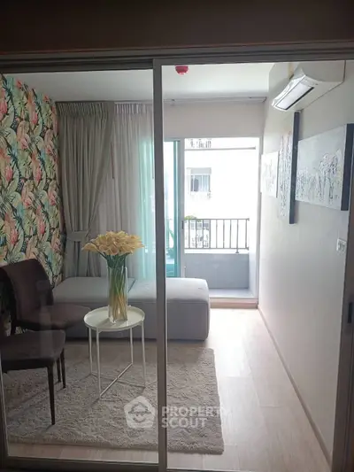 Chic living room with floral accent wall and cozy balcony in modern apartment