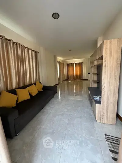 Spacious living room with modern sofa and elegant curtains, perfect for family gatherings.