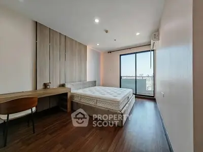 Spacious bedroom with modern design and city view balcony access.