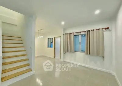 Spacious modern interior with staircase and large windows, perfect for stylish living.