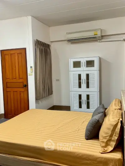 Cozy bedroom with air conditioning and stylish wardrobe, perfect for comfortable living.
