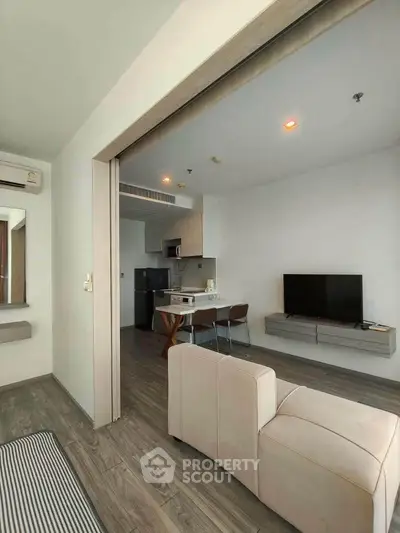 Modern open-plan living room with sleek kitchen and cozy seating area, perfect for urban living.