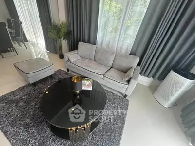 Stylish modern living room with plush gray sofa and chic black coffee table.