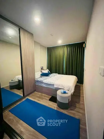 Cozy bedroom with mirrored wardrobe and modern decor in a stylish apartment.