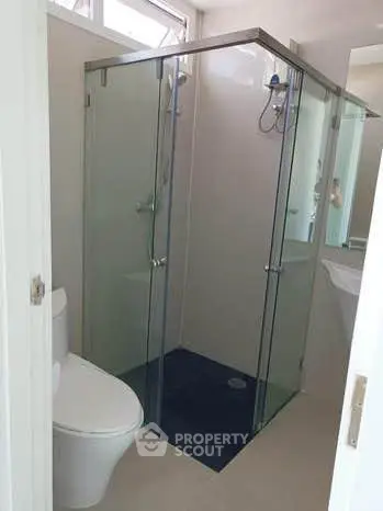 Modern bathroom with glass shower enclosure and sleek fixtures.