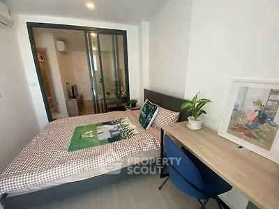 Modern bedroom with stylish decor and workspace, ideal for urban living.