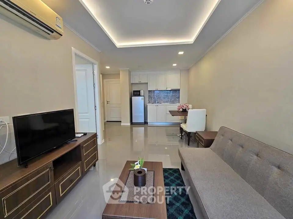 Modern living room with sleek furniture and open kitchen layout in a stylish apartment.