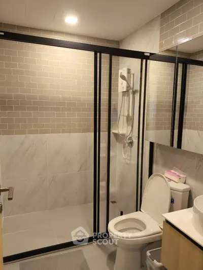 Modern bathroom with glass shower enclosure and sleek tile design