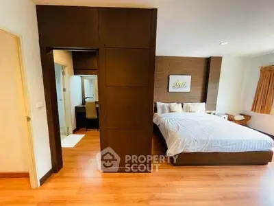 Spacious bedroom with modern decor and wooden flooring