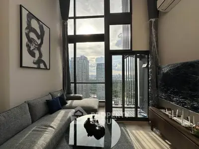 Luxurious high-rise living room with floor-to-ceiling windows and stunning city view.