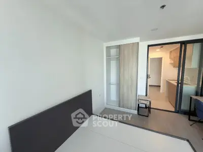 Modern bedroom with minimalist design and open view to kitchen area