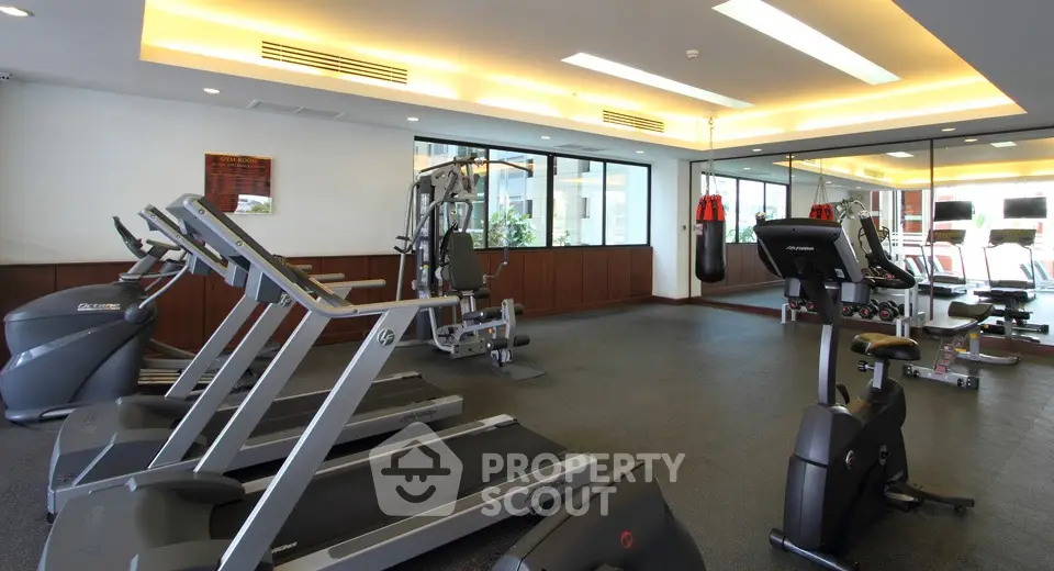 Spacious modern gym with state-of-the-art fitness equipment and large windows.
