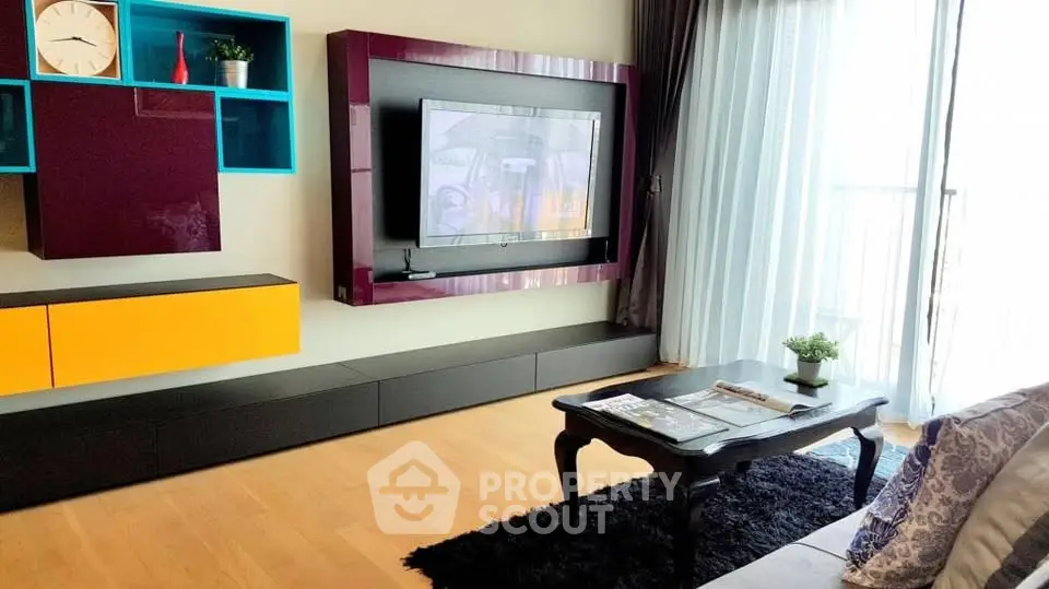 Stylish living room with modern decor and large window for natural light.
