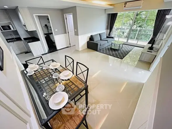 Spacious modern living room with dining area and balcony view