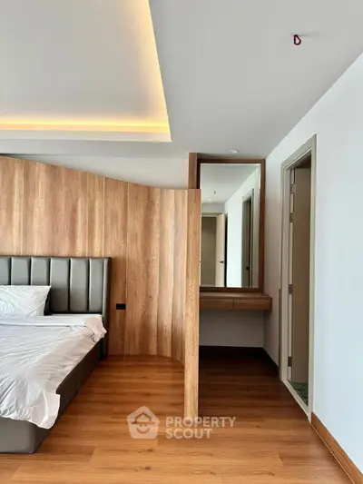 Modern bedroom with wooden accents and sleek design, featuring a cozy bed and stylish partition.
