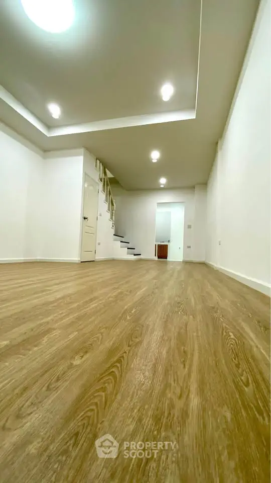 Spacious modern living room with wooden flooring and recessed lighting