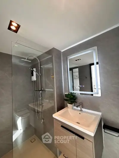 Modern bathroom with sleek shower and stylish vanity in contemporary apartment.