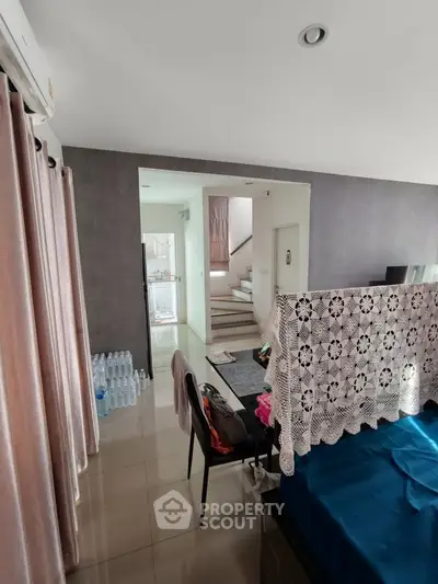 Spacious living area with modern decor and staircase leading to upper floor, perfect for family living.