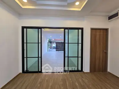 Spacious modern interior with sliding glass doors and wood flooring, perfect for open living.