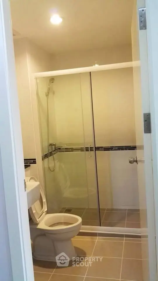 Modern bathroom with glass shower enclosure and tiled flooring